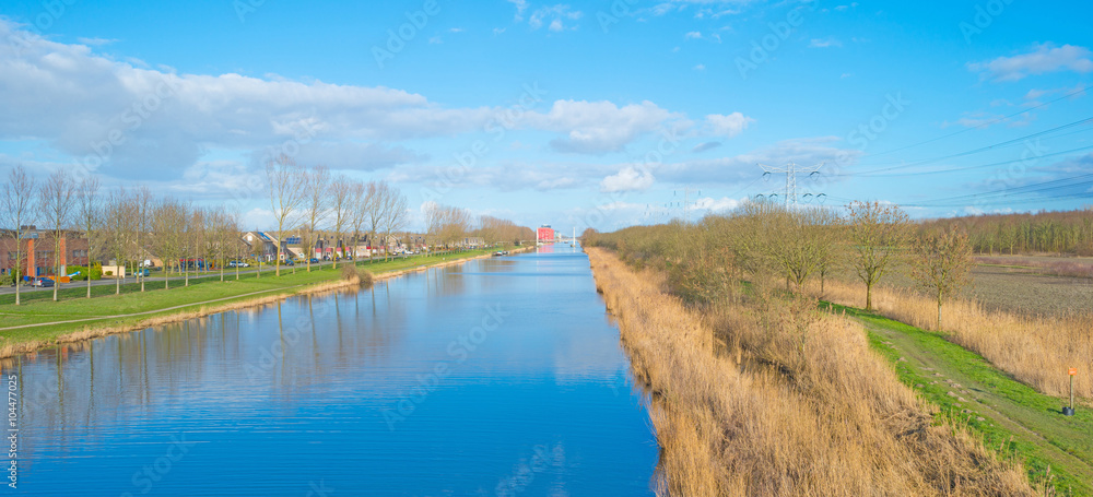 Canal through a sunny landscape in winter Canal through a sunny landscape in winter