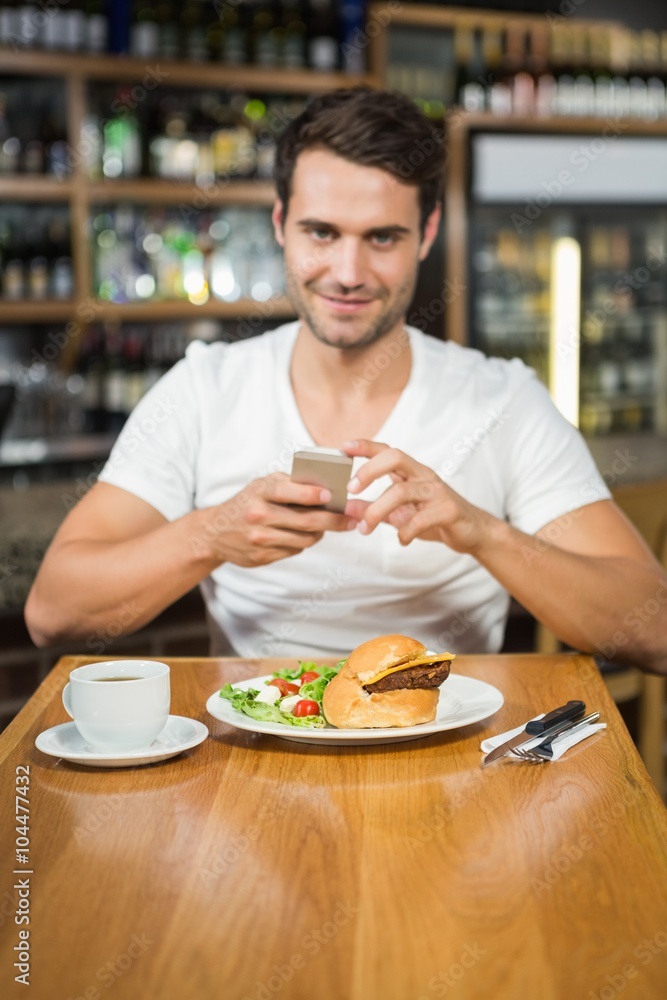 Handsome man taking a picture of his food Handsome man taking a picture of his food
