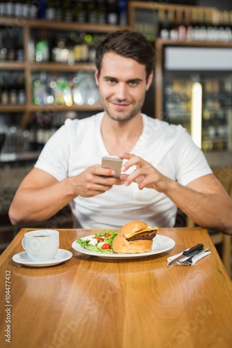 Handsome man taking a picture of his food