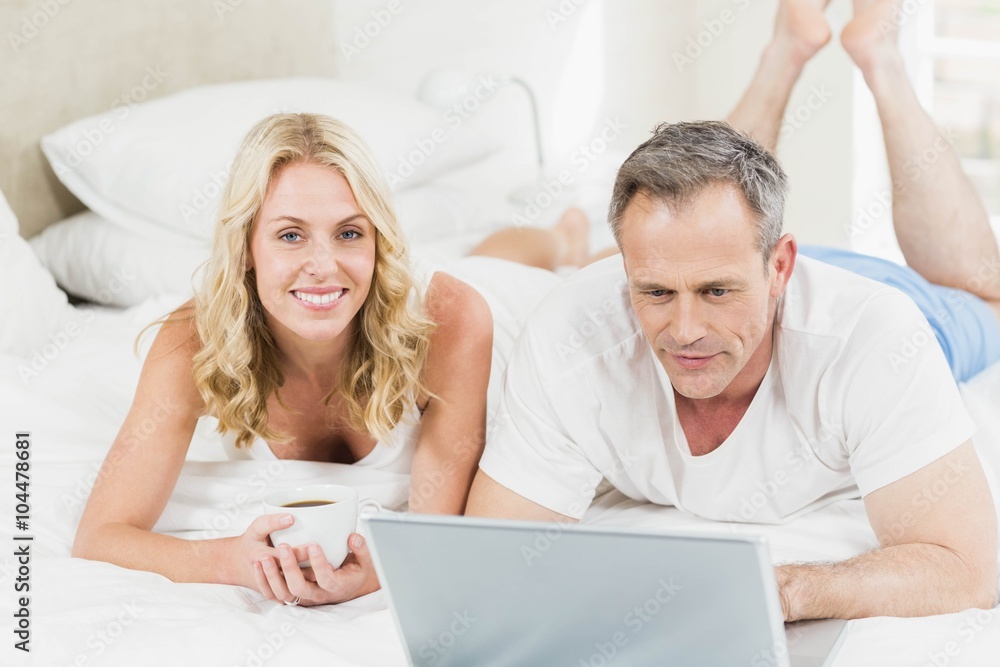 Cute couple using laptop in bed Cute couple using laptop in bed