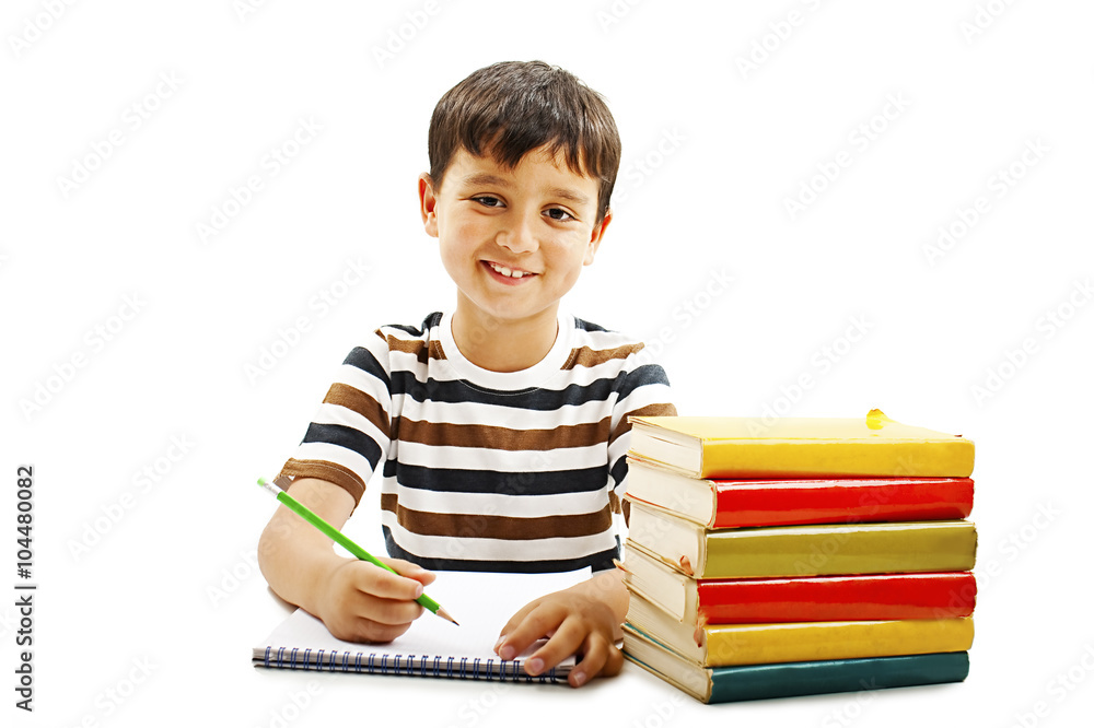 Smiling boy with school books on the table. Isolated on a white background Smiling boy with school books on the table. Isolated on a white background