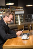 Thoughtful man using laptop and smartphone