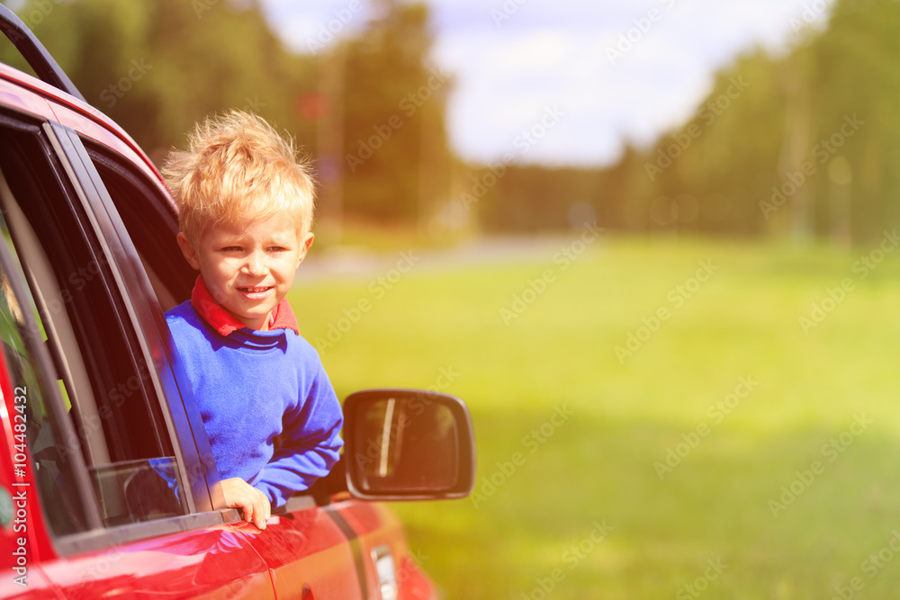 happy little boy travel by car in summer