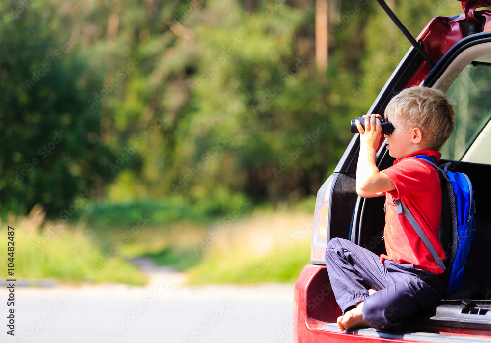 little boy looking through binoculars travel by car