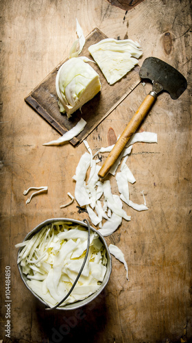 chopped cabbage in a pot and an old hatchet. photo