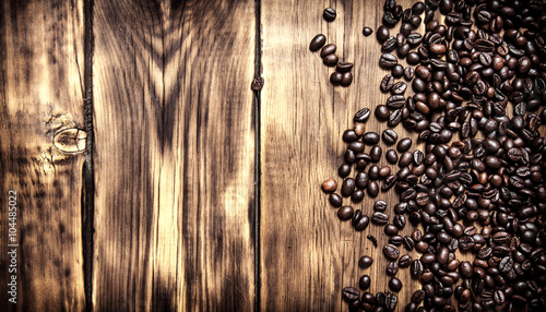 Fresh coffee beans. On wooden background.