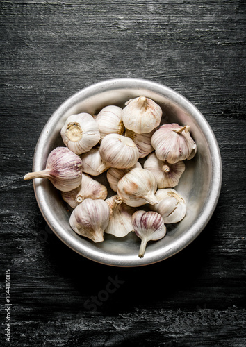 Fresh garlic in a metal bowl.