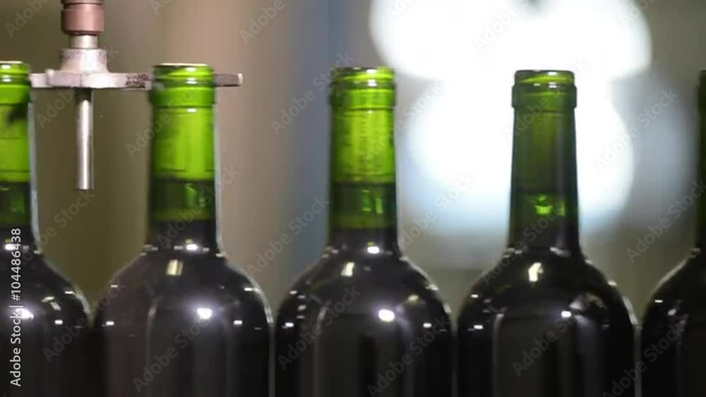 Wine bottles moving along a conveyor belt in a wine bottling factory. Wine bottles moving along a conveyor belt in a wine bottling factory.