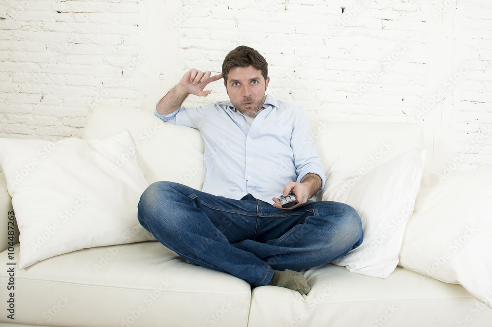 young happy man watching television in disbelief and shock face expression young happy man watching television in disbelief and shock face expression