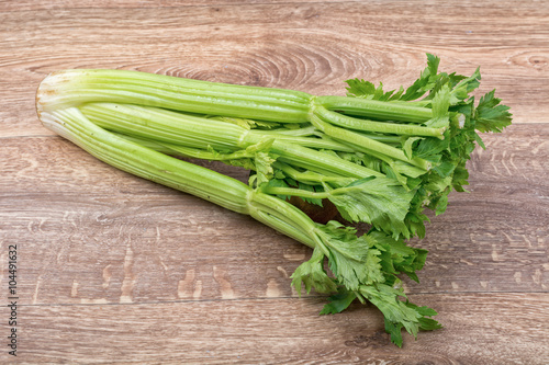 The green leaves of celery on a wooden background