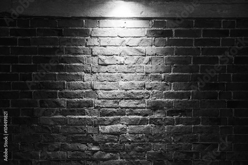 Grungy dark brick wall with spotlight