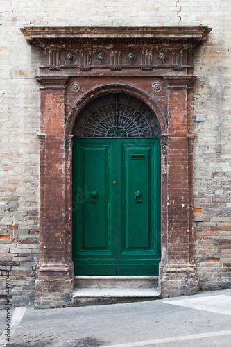 Green wooden door with arch and decoration