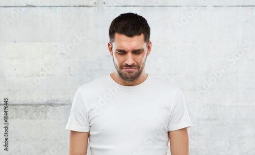 unhappy young man over gray wall background
