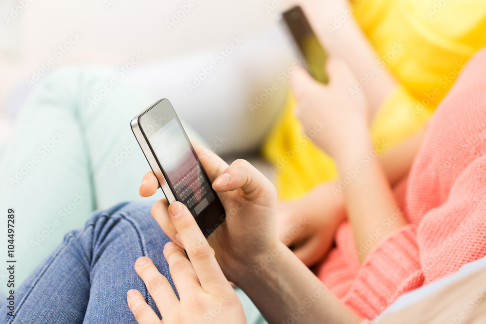 close up of hands texting on smartphone at home close up of hands texting on smartphone at home