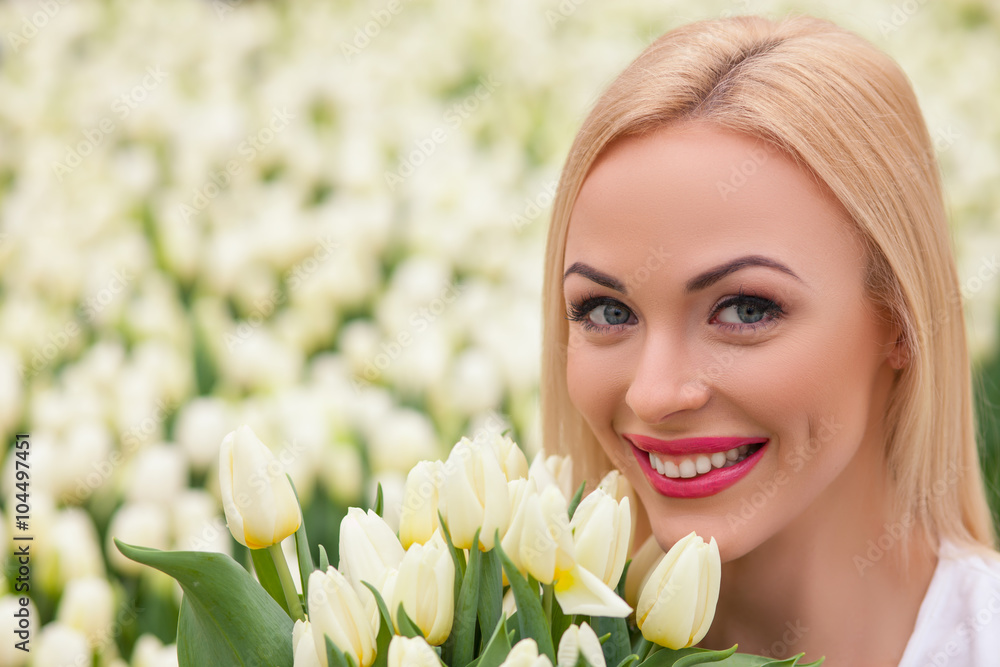 Cheerful young florist with white tulips Cheerful young florist with white tulips