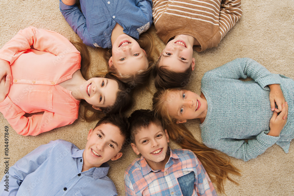 happy smiling children lying on floor in circle