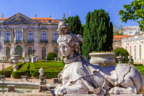 Queluz, Portugal. Sphinx sculpture at the Neptune gardens and Cerimonial Facade on the Queluz Royal Palace. Formerly used as the Summer residence by the Portuguese royal family.