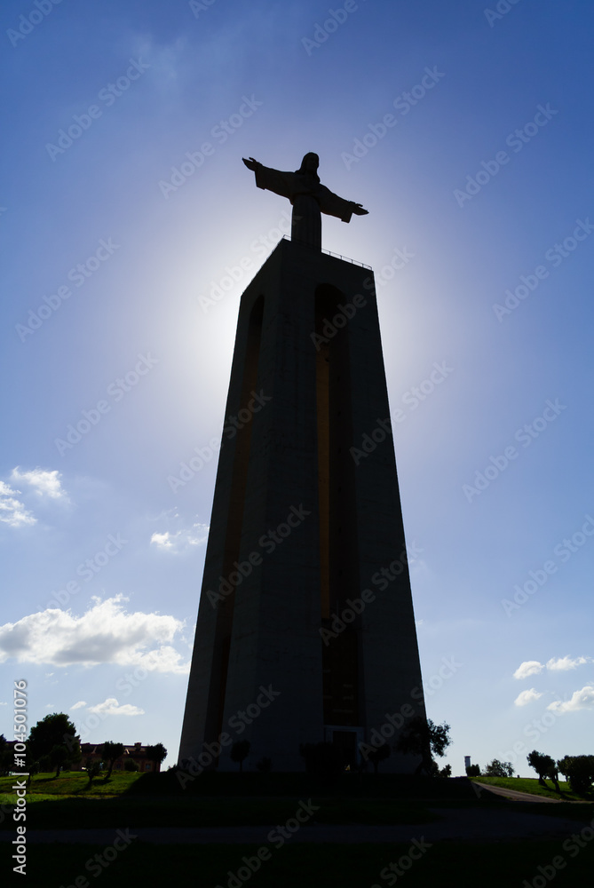 Backlit image with the silhouette of the famous Cristo-Rei or King-Christ Sanctuary in Almada. This is the second most visited sanctuary in Portugal, and a Lisbon  landmark.