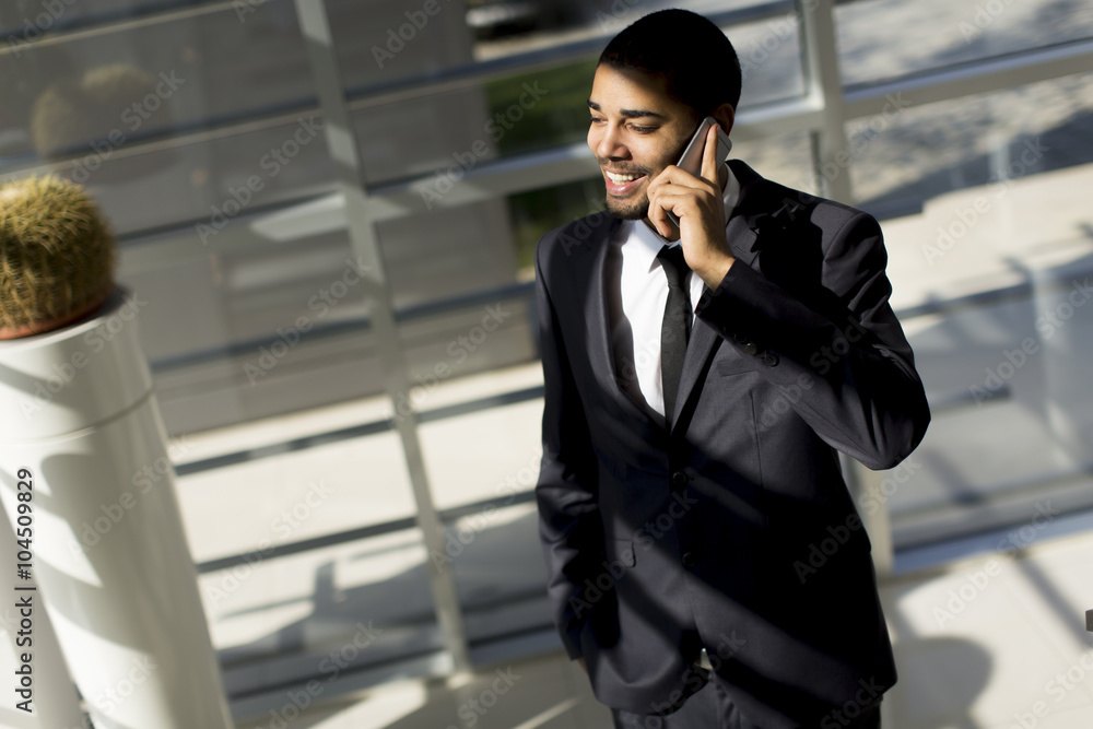 Young black man with telephone in the office Young black man with telephone in the office