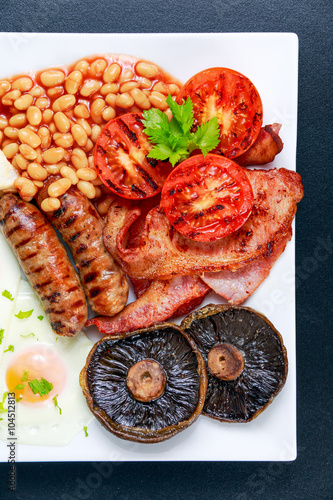 Fototapeta Naklejka Na Ścianę i Meble -  Full English breakfast with bacon, sausage, egg, beans and mushrooms