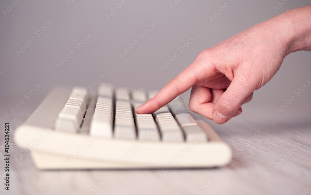 Close up of hand pressing keyboard buttons Close up of hand pressing keyboard buttons