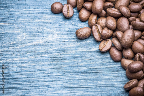 Coffee seeds on blue wood background.