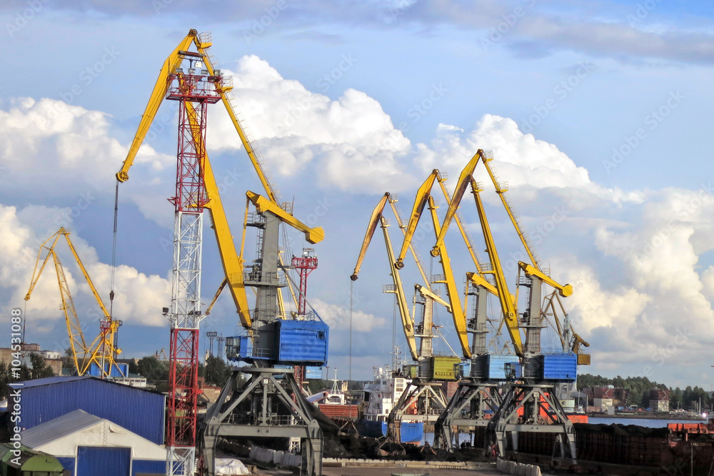 port cranes against the blue sky with clouds