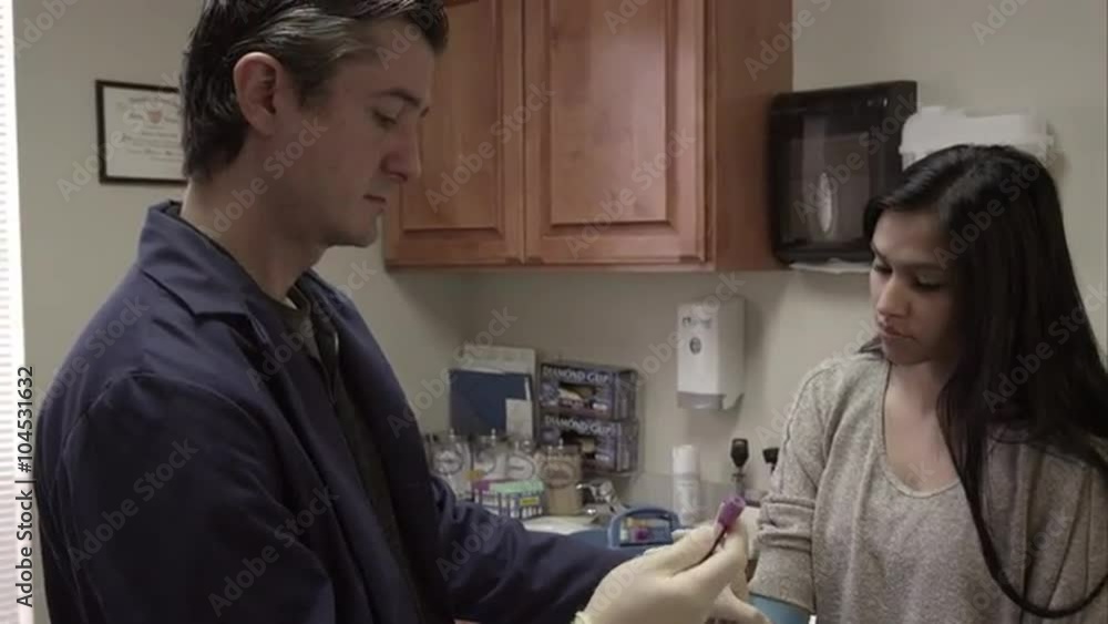 Doctor taking a blood sample from woman's arm. Doctor taking a blood sample from woman's arm.