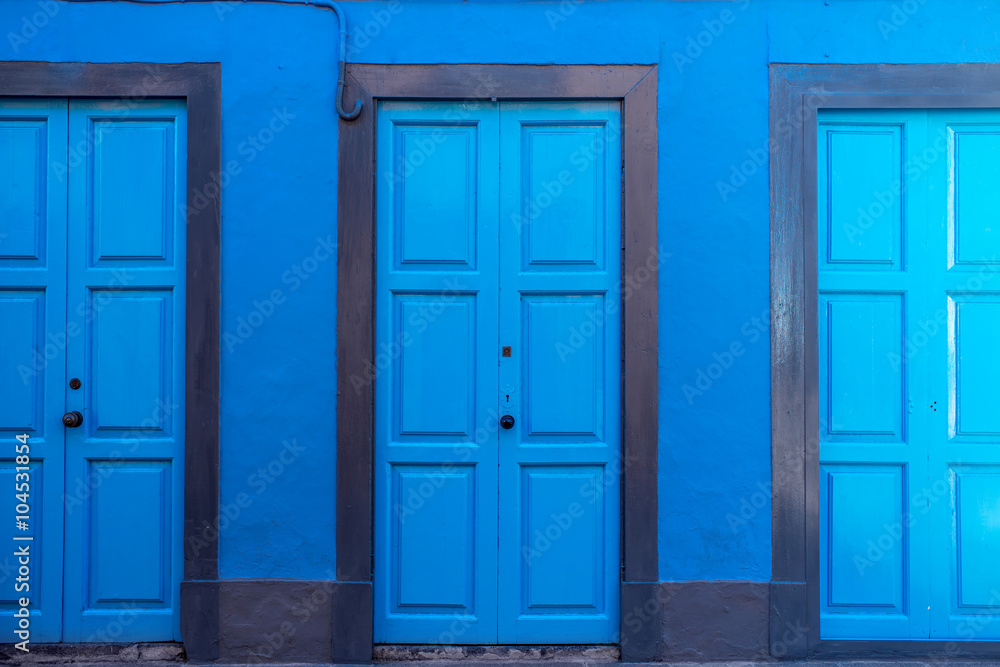 Background with three blue doors on the blue wall 