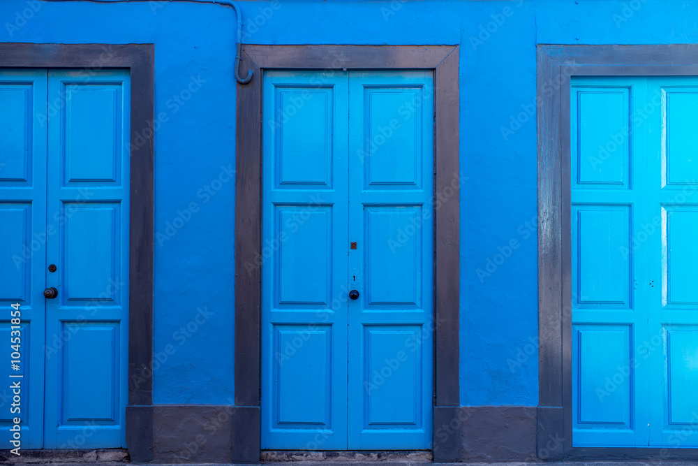 Background with three blue doors on the blue wall Background with three blue doors on the blue wall