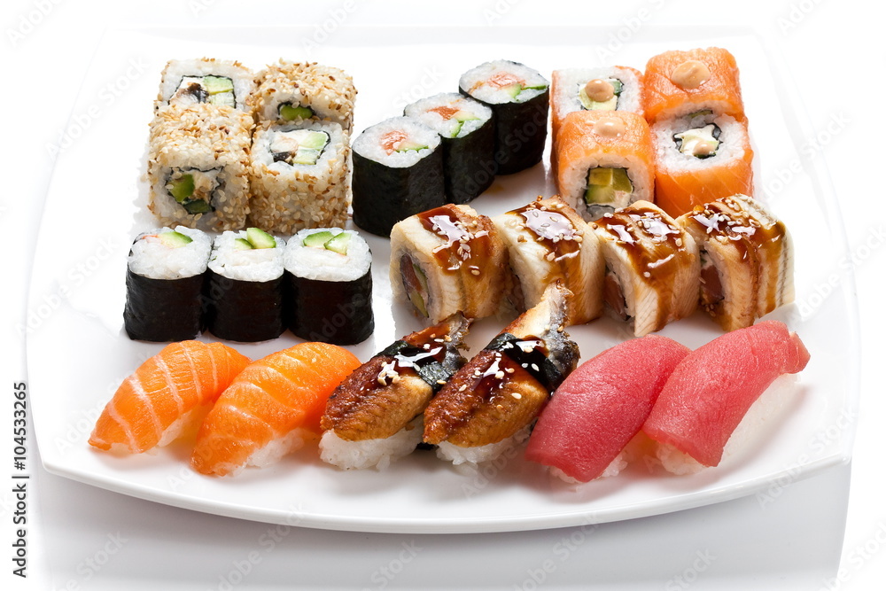 Sushi rolls assortment on a white plate. Different kinds of sushi side view. Big and mouthwatering sushi set Sushi rolls assortment on a white plate. Different kinds of sushi side view. Big and mouthwatering sushi set