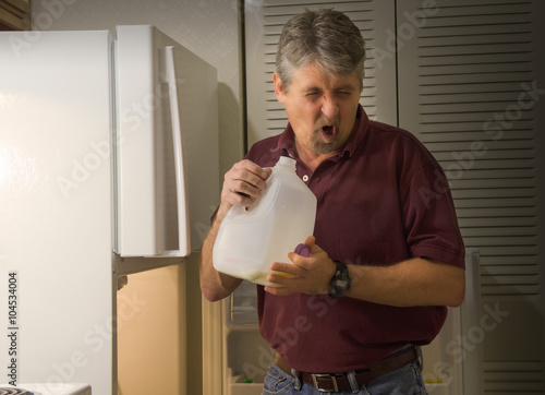 A man with a disgusted wretched look on his face was caught off guard when he checked the milk with the sniff test only to find it was spoiled rotten sour milk