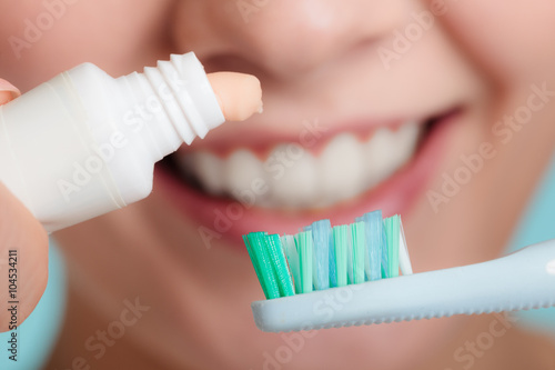 Fotografia Woman putting toothpaste on toothbrush