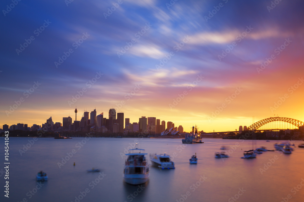Fototapeta premium Australia Sydney City Widok CBD z punktu kremacji nad wodami portu o zachodzie słońca, wykonany techniką długiej ekspozycji