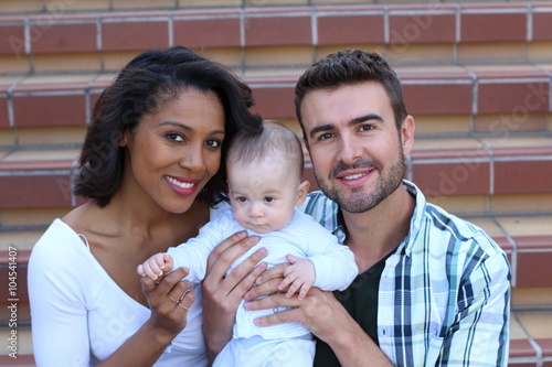 Happy Young Attractive Mixed Race Couple with Newborn Baby.