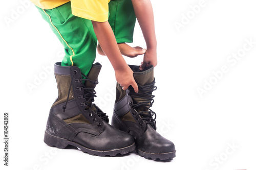 little boy try wearing big shoe