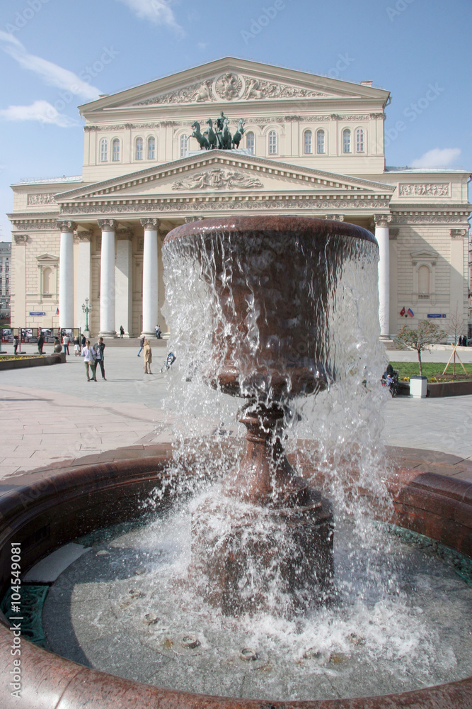 Fountain / Moscow, Russia - May 2, 2015: Tourists walk on square in front of the Bolshoi Theatre and admire the fountain