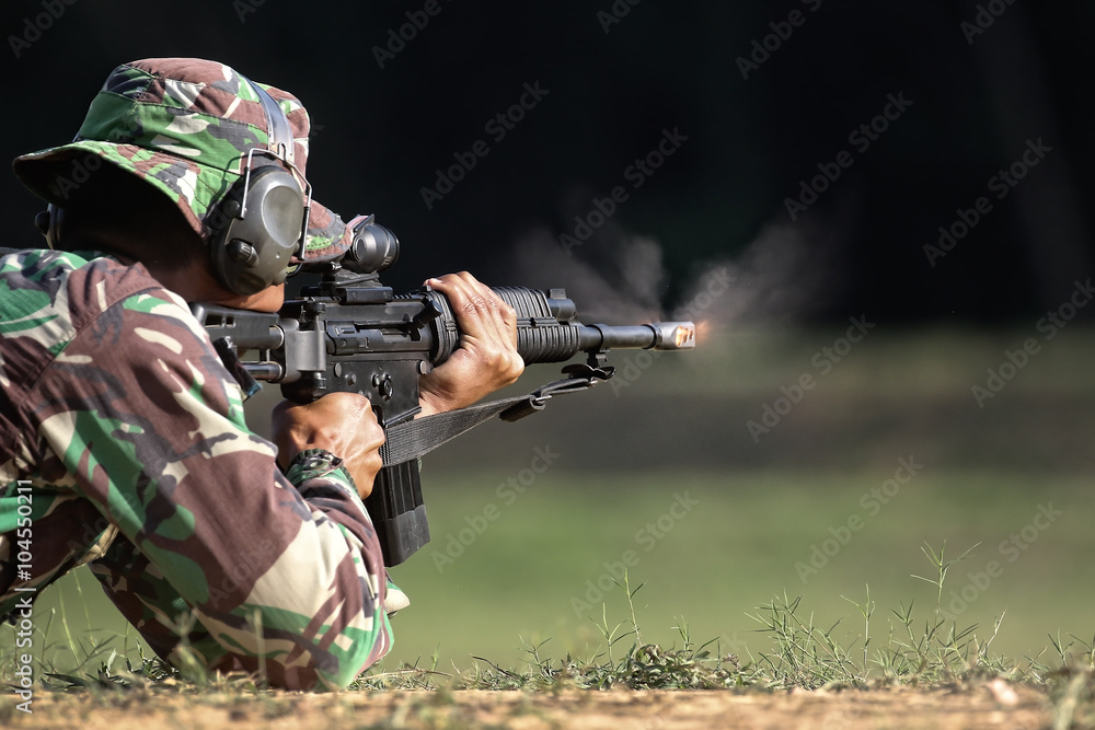Soldier shooting gun with fire and smoke at the muzzle