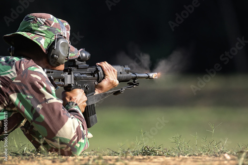 Soldier shooting gun with fire and smoke at the muzzle