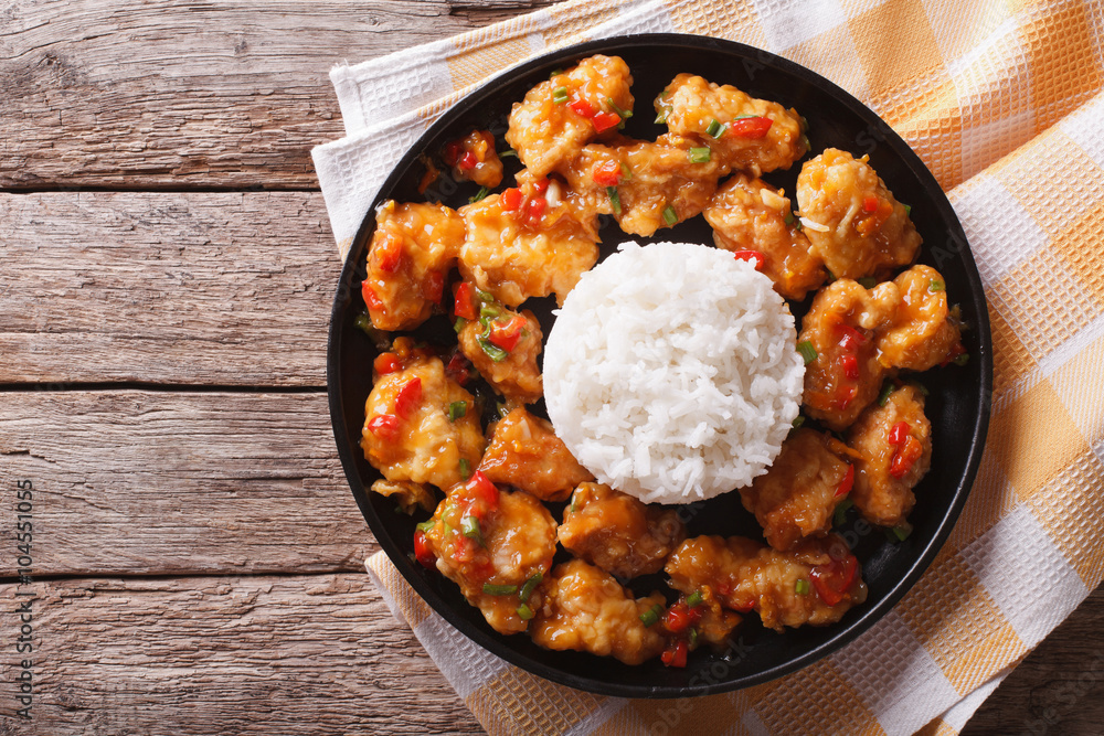 chicken in orange sauce with rice on a plate. horizontal top view
