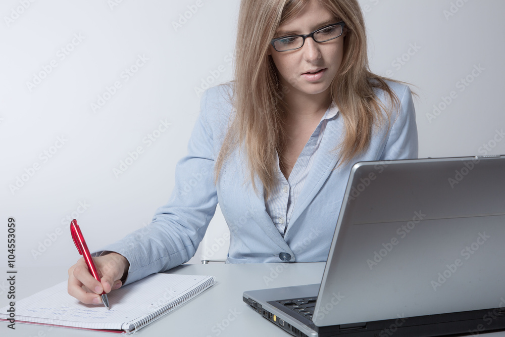Junge Frau arbeitet im Büro am Laptop