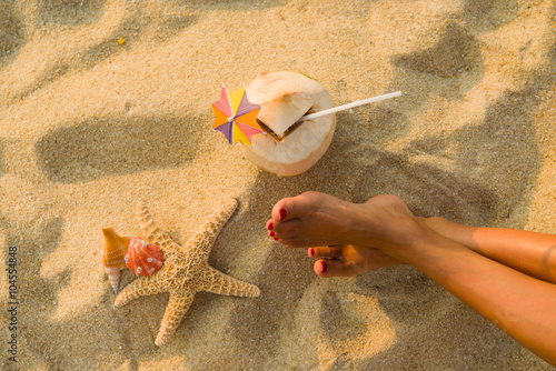 Slika na platnu young woman on the beach with coconut, starfish  and seashell