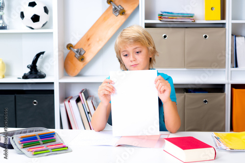 boy on desk with bad report card