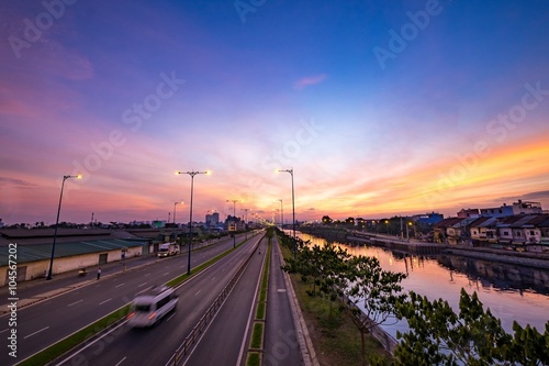 Colourful sunrise on Tau Hu canal and the East-West Highway (Vo Van Kiet street) in Ho Chi Minh City (Saigon). HO CHI MINH, VIETNAM photo