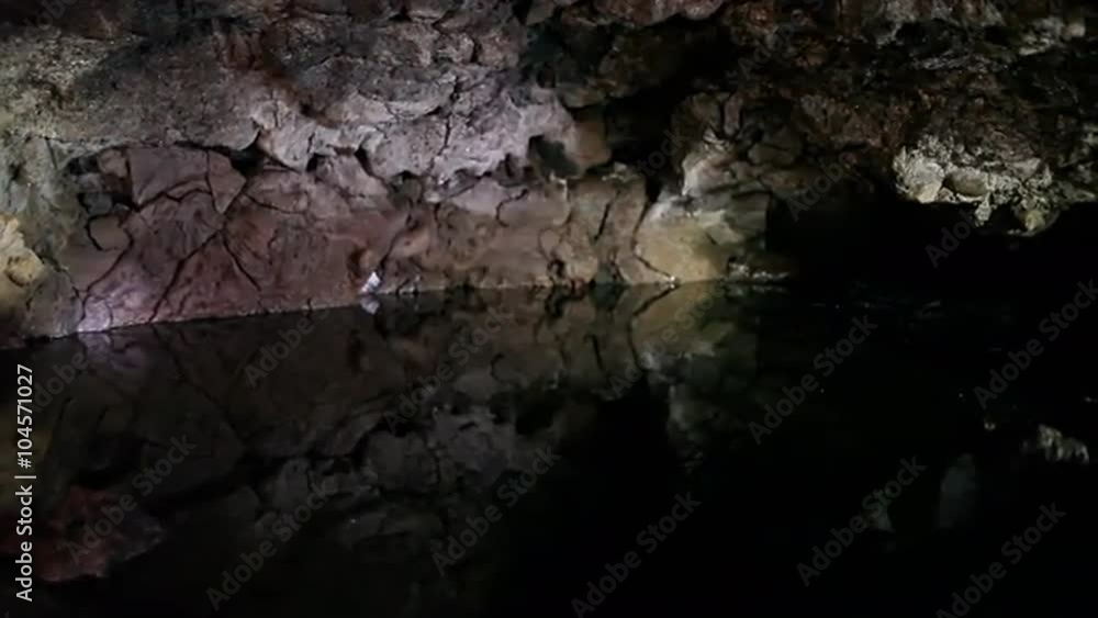 Bats fly in around a cave with a pool at night. Bats fly in around a cave with a pool at night.