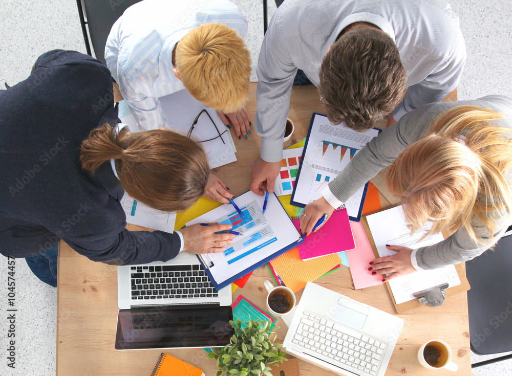 Image of business partners discussing documents and ideas at meeting Image of business partners discussing documents and ideas at meeting