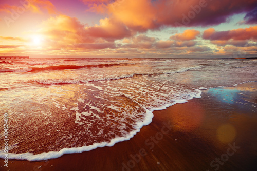 Fototapeta Naklejka Na Ścianę i Meble -  Sunset over sea with oncoming waves