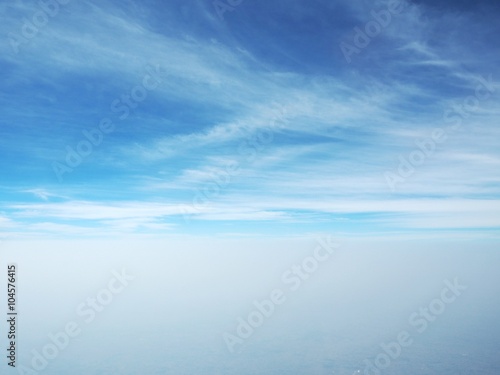 Fluffy white clouds and blue sky seen from airplane
