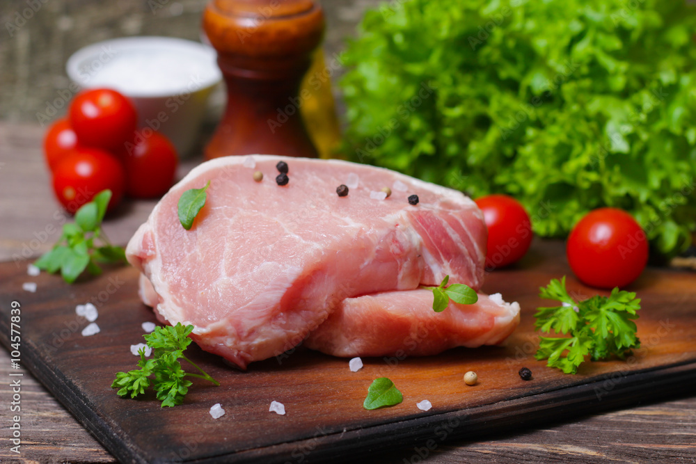 Sliced pieces of raw meat for barbecue with fresh Vegetables (tomatoes, lettuce) on wooden surface. Meat raw stacked on wooden background, beef Steak BBQ. Sliced pieces of raw meat for barbecue with fresh Vegetables (tomatoes, lettuce) on wooden surface. Meat raw stacked on wooden background, beef Steak BBQ.
