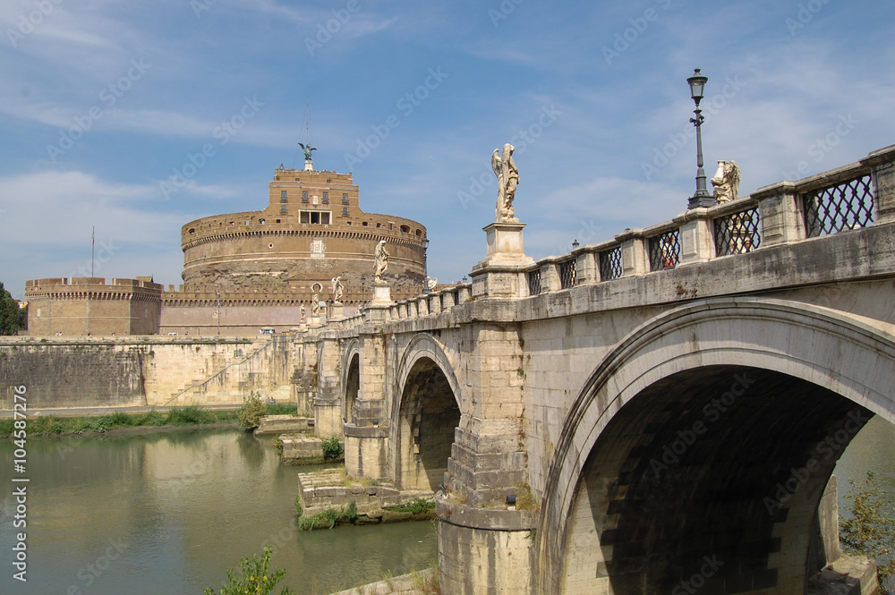 Round tower of the castle and figures of angels on the bridge